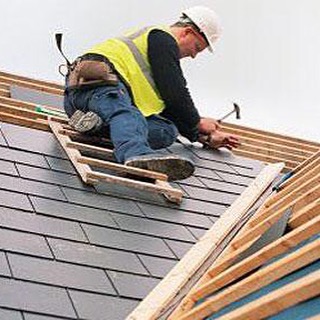 image of man of roof of new home laying shingels